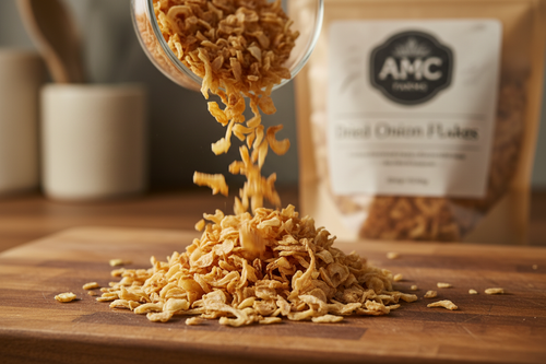 Close-up of dried onion flakes spilling from a glass bowl onto a wooden cutting board