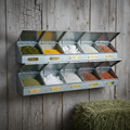 12-compartment galvanized steel mineral buffet feeder mounted on barn wall with colored minerals in each compartment