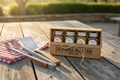 Three AMC Farms spice jars in an open kraft gift box on a rustic wooden table
